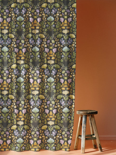 Luxury blackout curtain panel featuring a dark background with a symmetrical botanical pattern of embroidered-style wildflowers in muted pastel and golden tones. The curtain has a rich satiny texture and a 4-inch rod pocket top. Printed on one side, white backing.
